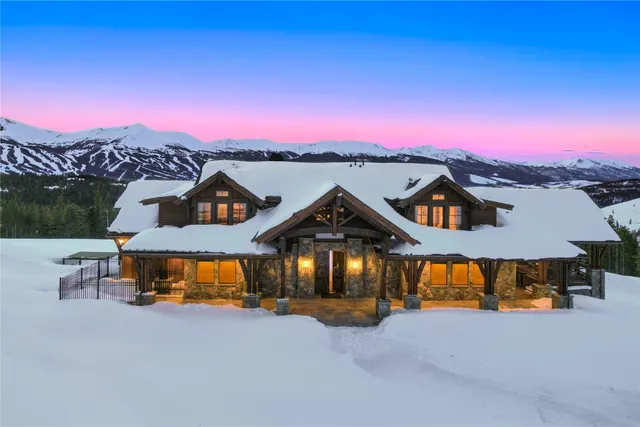 a front view of a house with a yard and a large tree
