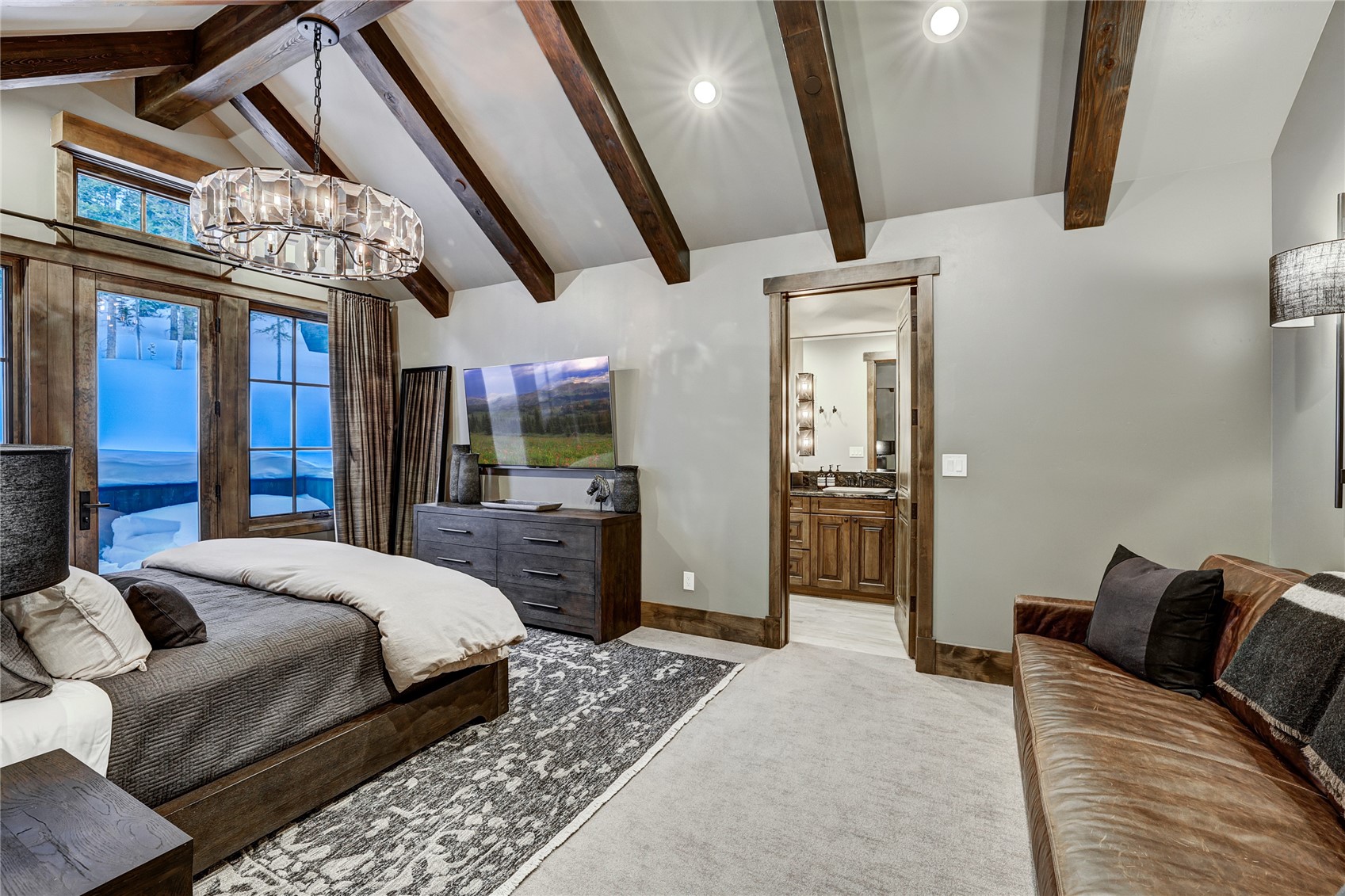 250 Sallie Barber Road Breckenridge, CO 80424 - Photo 31 of 50 a bedroom with a large bed a chandelier and dresser