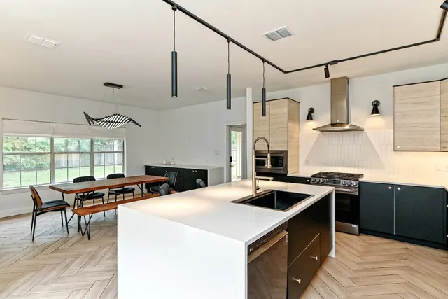 a kitchen with a sink a stove and cabinets