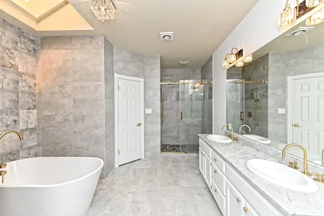 a large white tub sitting next to a bathroom sink