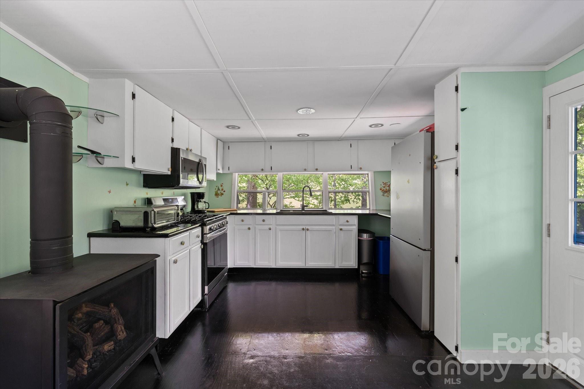 72 Amos Creek Road Marshall, NC 28753 - Photo 7 of 28 a kitchen with stainless steel appliances kitchen island granite countertop a refrigerator a sink a stove a microwave and island