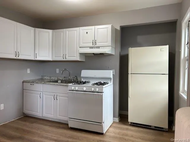 a kitchen with a stove a refrigerator and cabinets
