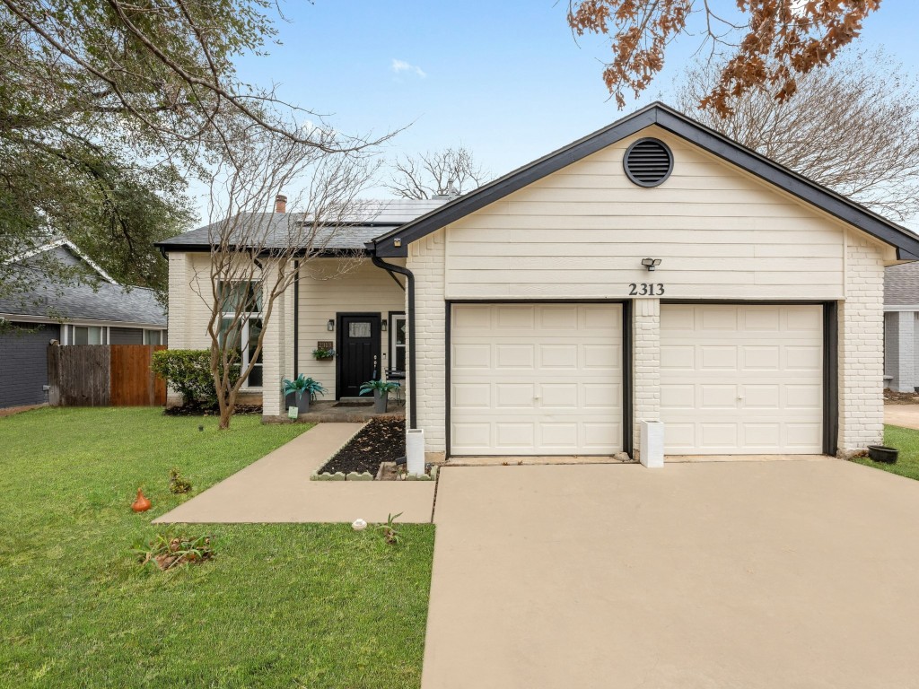 a view of a house with a yard and garage