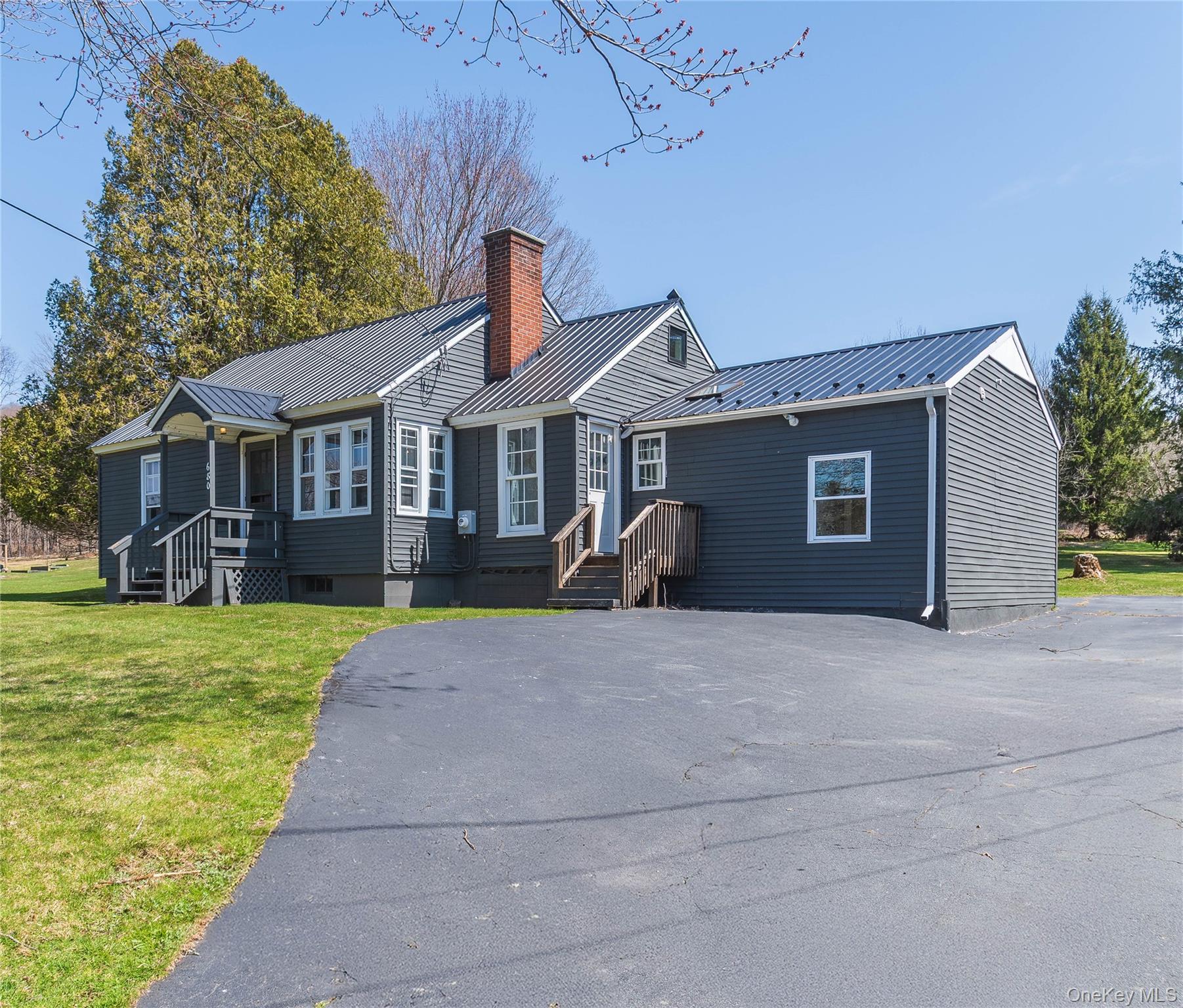 a front view of a house with a garden and yard