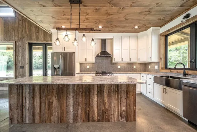 a large kitchen with granite countertop a sink window and refrigerator