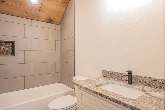 a bathroom with a granite countertop sink and mirror