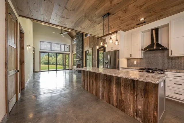 a kitchen with stainless steel appliances granite countertop a stove a sink and a refrigerator