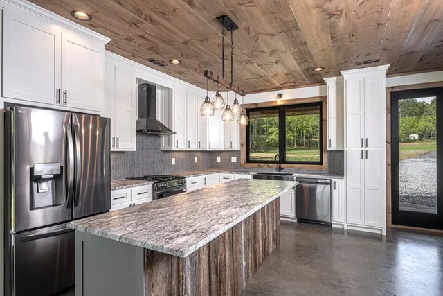 a kitchen with stainless steel appliances granite countertop a refrigerator a sink and a stove