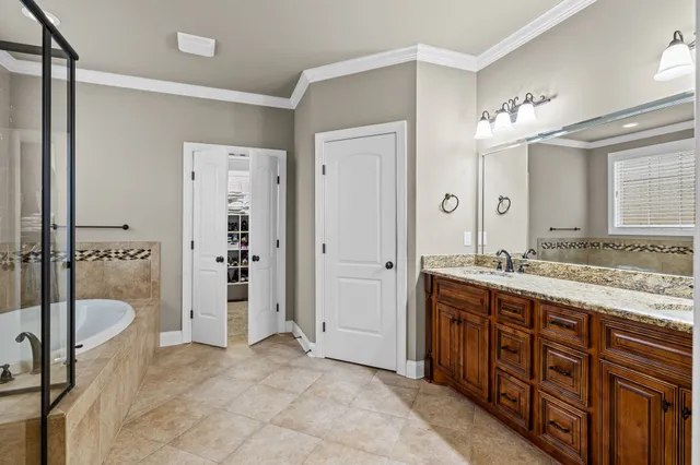 a spacious bathroom with a tub sink and mirror