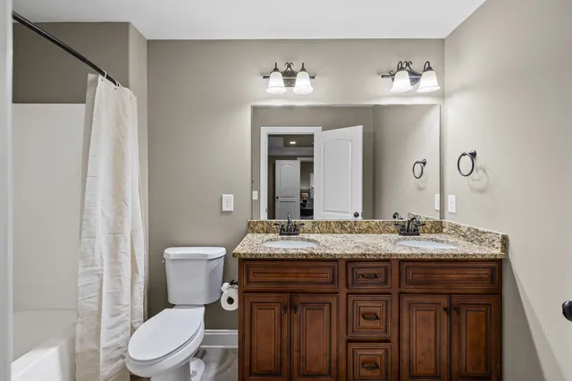 a bathroom with a sink vanity mirror and toilet