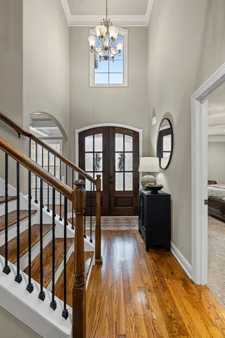 a bedroom with furniture a chandelier and wooden floor