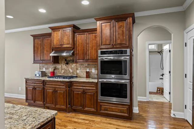 a kitchen with stainless steel appliances granite countertop a stove a sink and a refrigerator