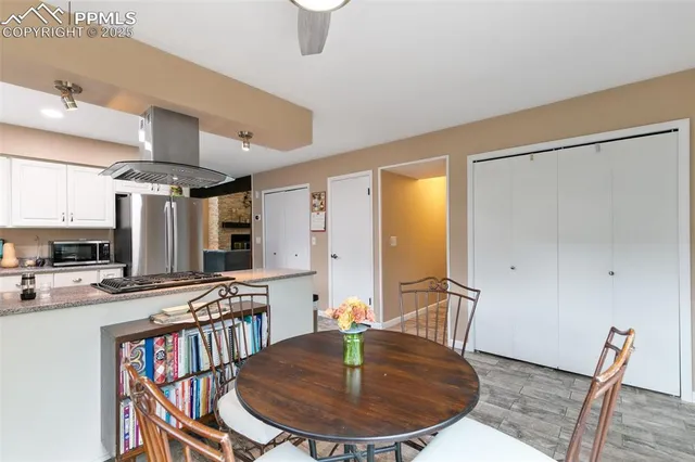 a kitchen with stainless steel appliances granite countertop a stove a sink and a dining table