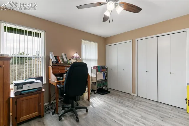 a view of a workspace with furniture and a window