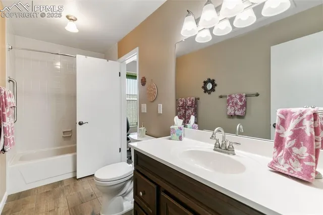 a bathroom with a sink a toilet a tub and shower