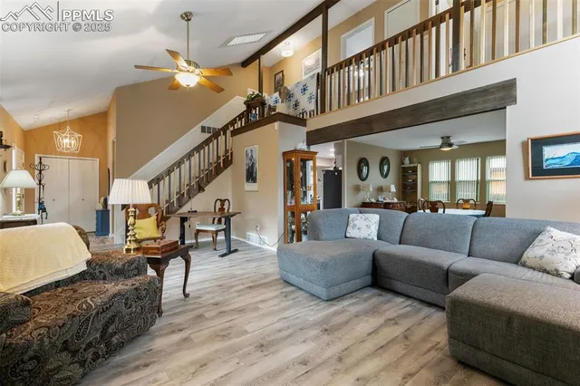 a living room with furniture and a ceiling fan