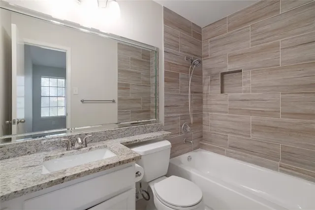 a bathroom with a granite countertop toilet a sink and bathtub