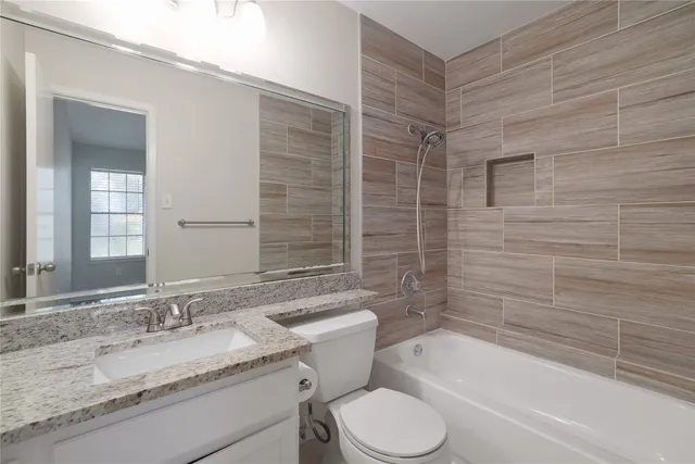 a bathroom with a granite countertop sink toilet and bathtub