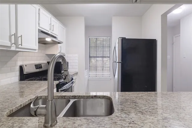 a kitchen with a sink and a stove top oven