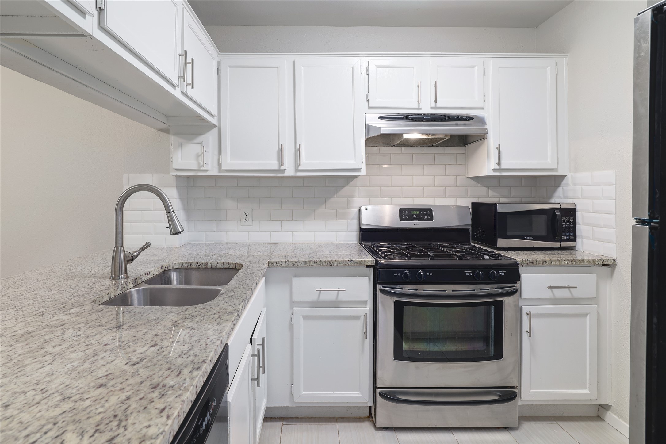 11404 Walnut Ridge Drive, Unit 4 Austin, TX 78753 - Photo 6 of 15 a kitchen with granite countertop a stove sink and cabinets