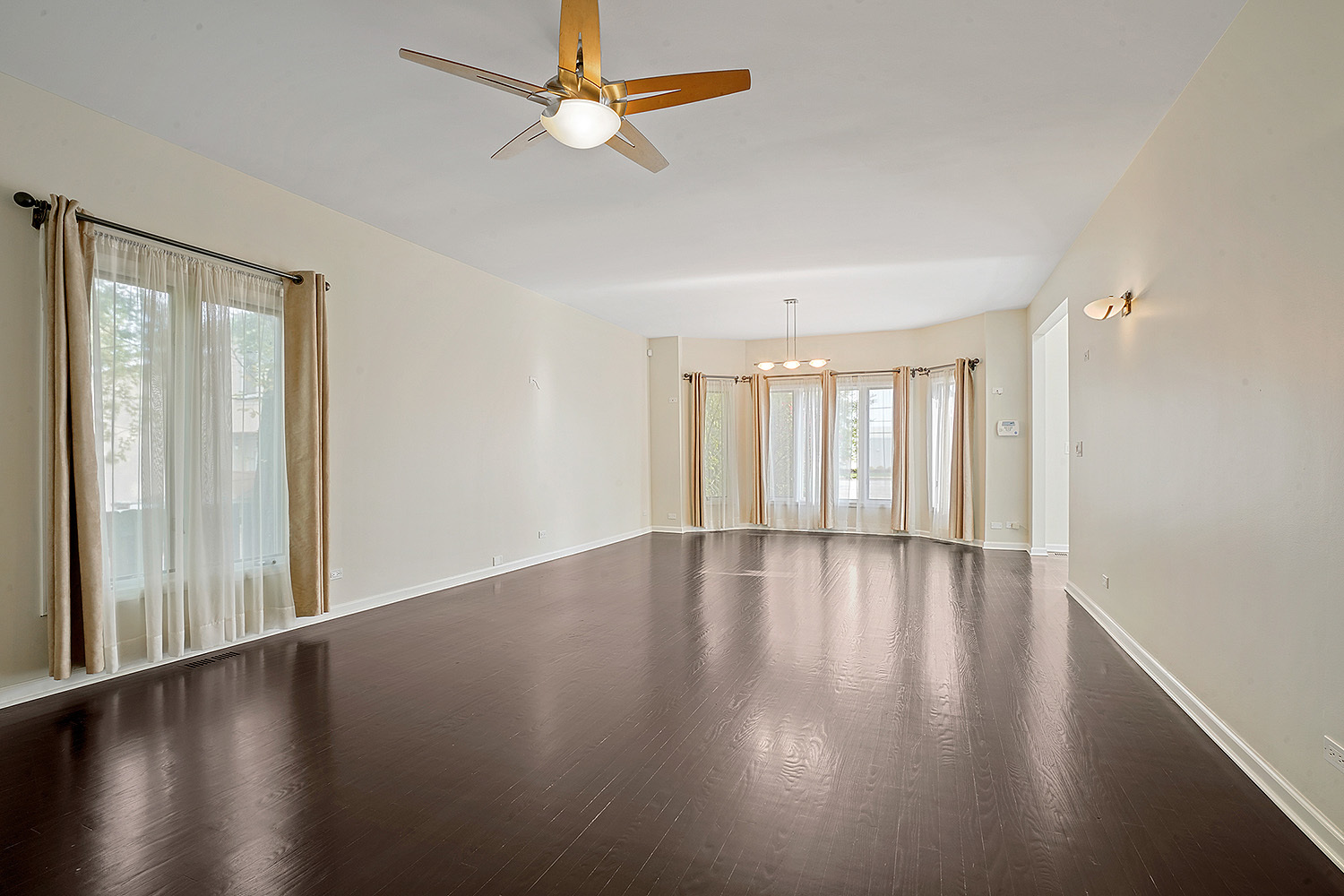 2134 Shermer Road Northbrook, IL 60062 - Photo 9 of 20 an empty room with wooden floor and windows with curtains