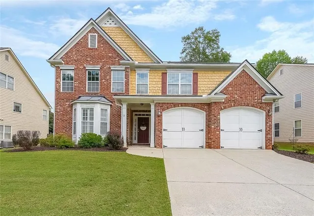a front view of a house with a garden