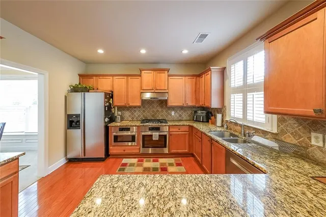 a kitchen with stainless steel appliances granite countertop a stove and a sink