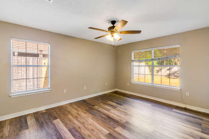 122 Bayou Landing Road Miramar Beach, FL 32550 - Photo 15 of 27 a view of an empty room with chandelier fan and wooden floor