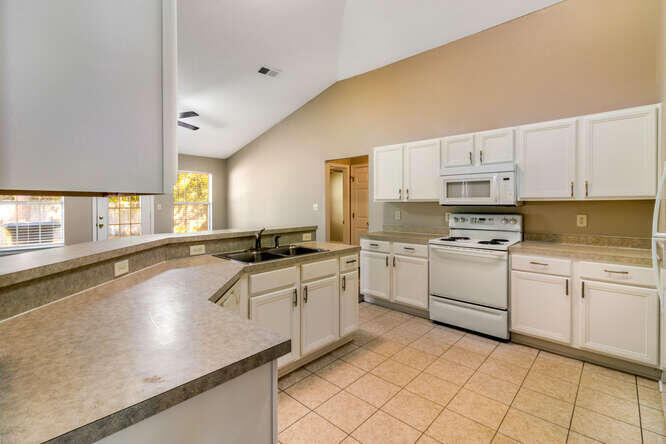 122 Bayou Landing Road Miramar Beach, FL 32550 - Photo 10 of 27 a kitchen with granite countertop white cabinets and white appliances