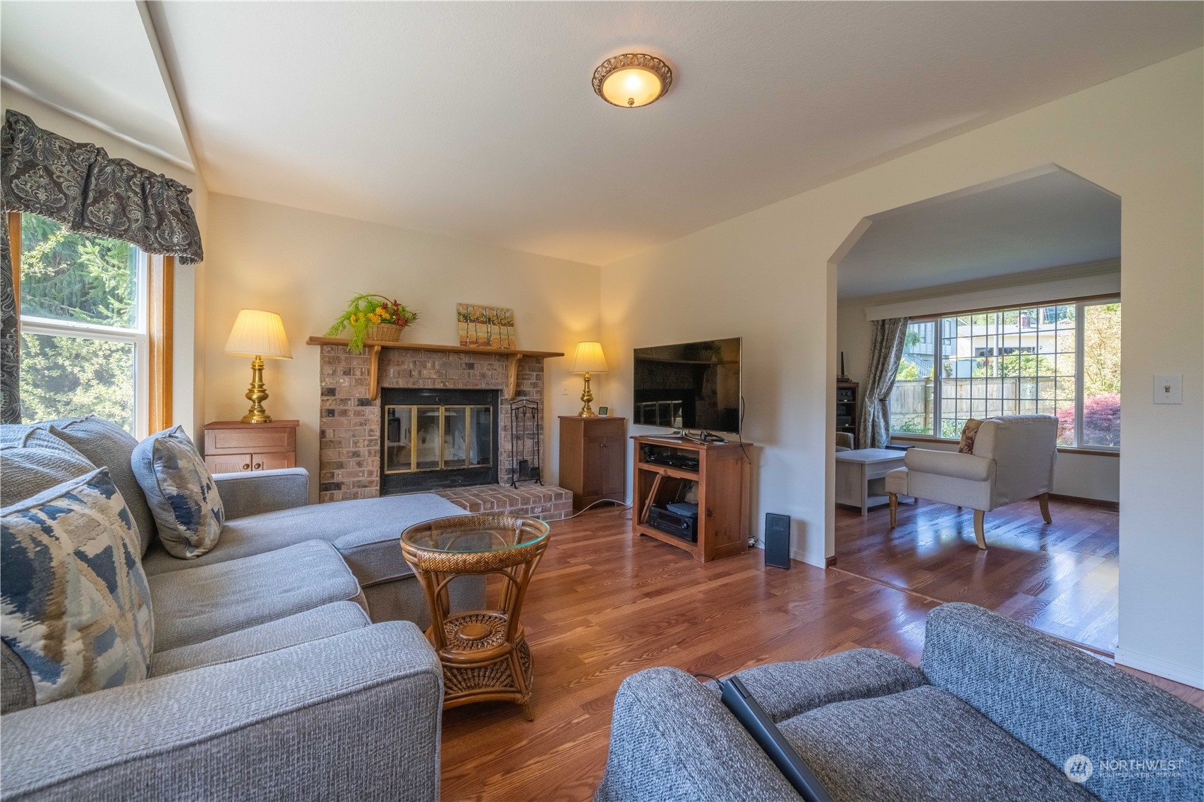 414 169th Street Southeast Bothell, WA 98012 - Photo 6 of 24 a living room with furniture a fireplace a flat screen tv and windows