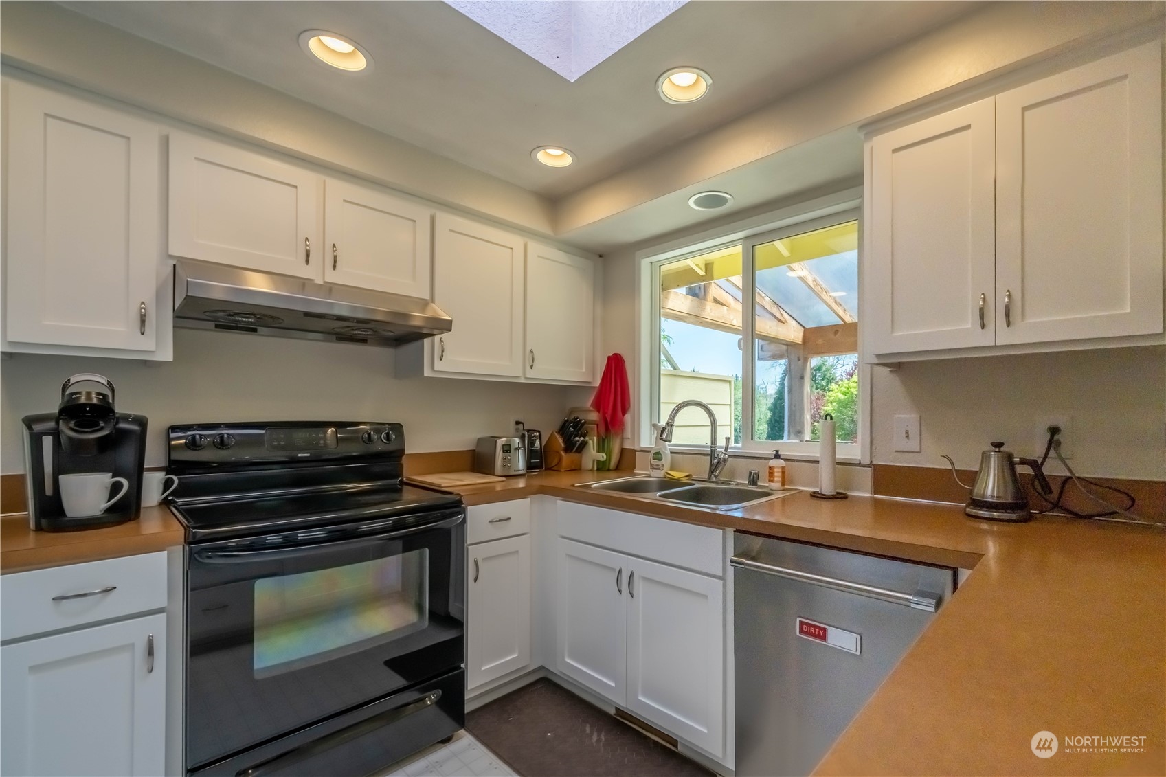 414 169th Street Southeast Bothell, WA 98012 - Photo 9 of 24 a kitchen with stainless steel appliances granite countertop a sink a stove a microwave a refrigerator and cabinets