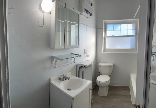 a bathroom with a toilet sink and mirror