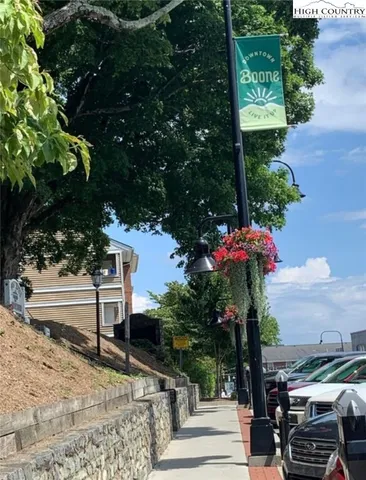 a tree lined with flowers on a sidewalk