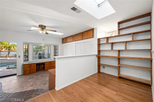 a view of a big room with wooden floor and ceiling fan
