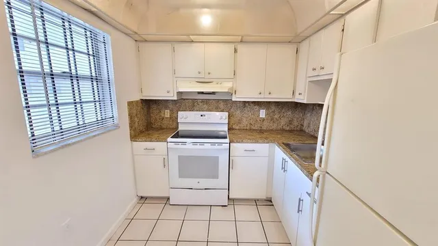 a kitchen with a stove top oven sink and cabinets