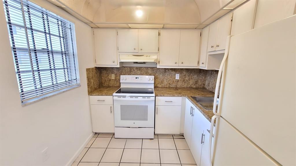 15600 Northwest 7th Avenue, Unit 606 Miami, FL 33169 - Photo 3 of 13 a kitchen with a stove top oven sink and cabinets