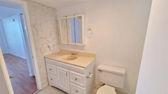a bathroom with a sink toilet vanity and tub
