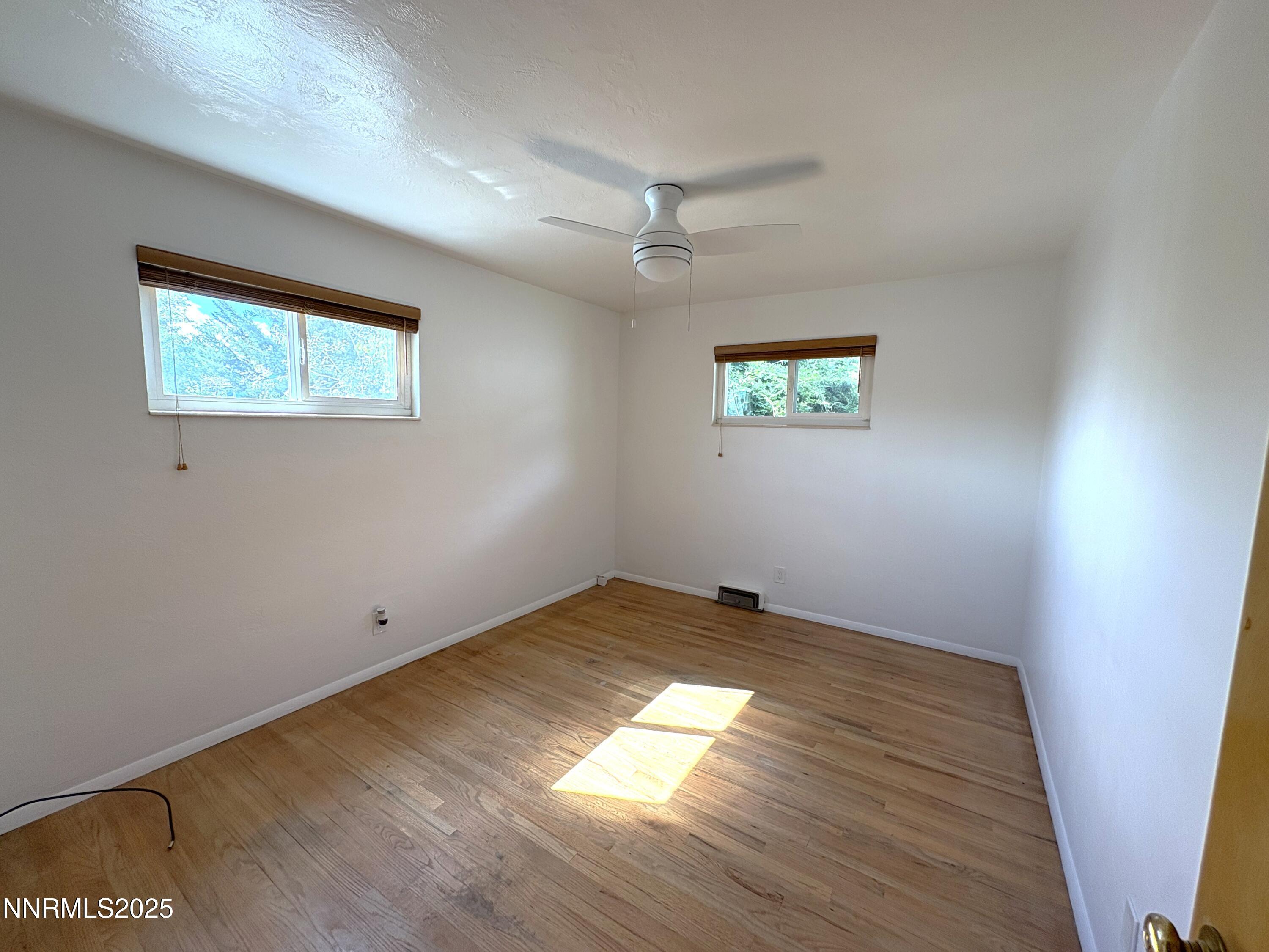230 Glenmanor Drive Reno, NV 89509 - Photo 14 of 28 an empty room with wooden floor and windows