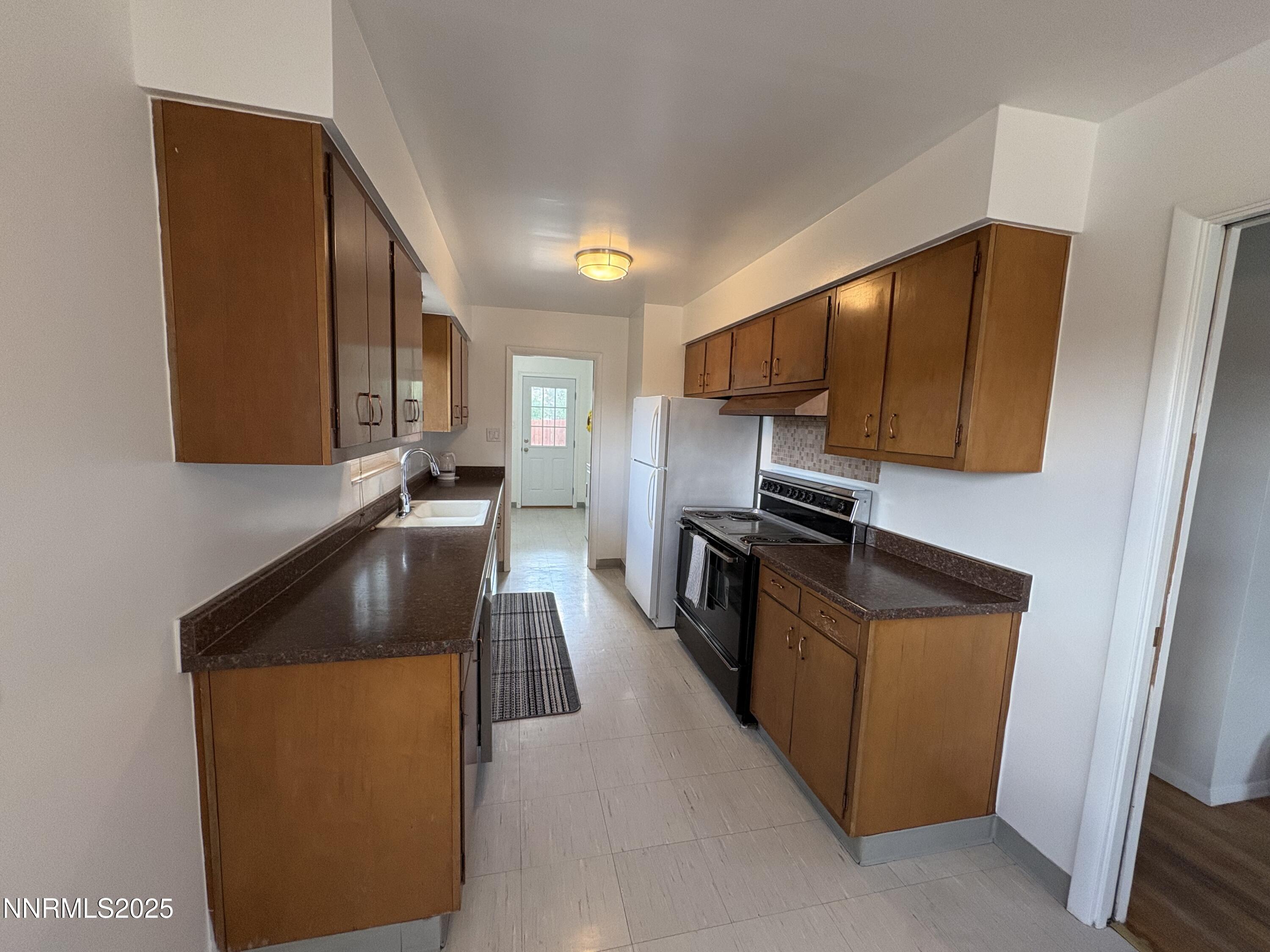 230 Glenmanor Drive Reno, NV 89509 - Photo 7 of 28 a kitchen with granite countertop stainless steel appliances and wooden cabinets