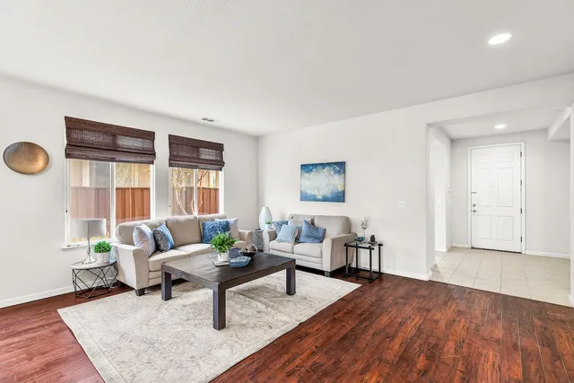 a dining room with furniture a large window and wooden floor