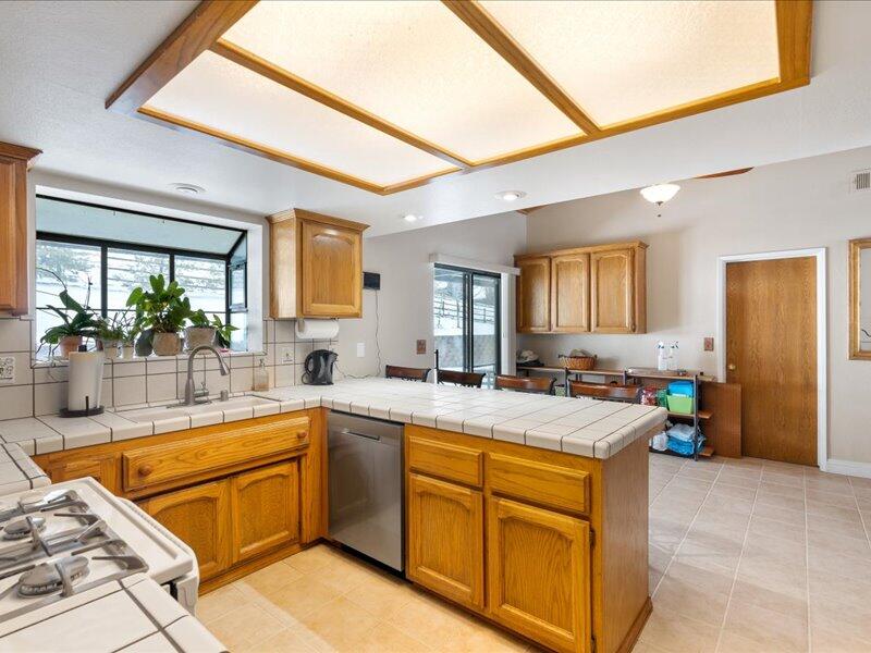 24140 Deertrail Drive Tehachapi, CA 93561 - Photo 11 of 44 a kitchen with a sink a counter top space and living room