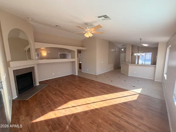 a view of an empty room and kitchen view