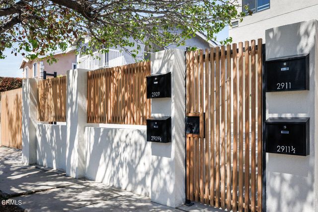 a view of a house with a door and wooden fence
