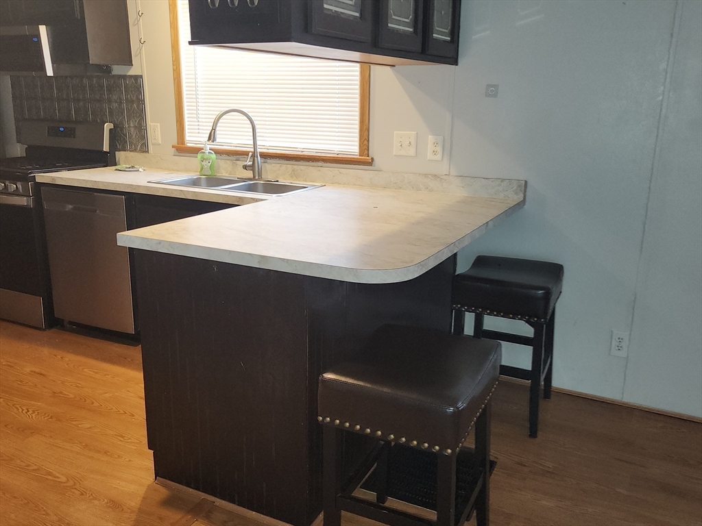8 Chesapeake Road Holbrook, MA 02343 - Photo 15 of 27 a kitchen with a sink a table and chairs