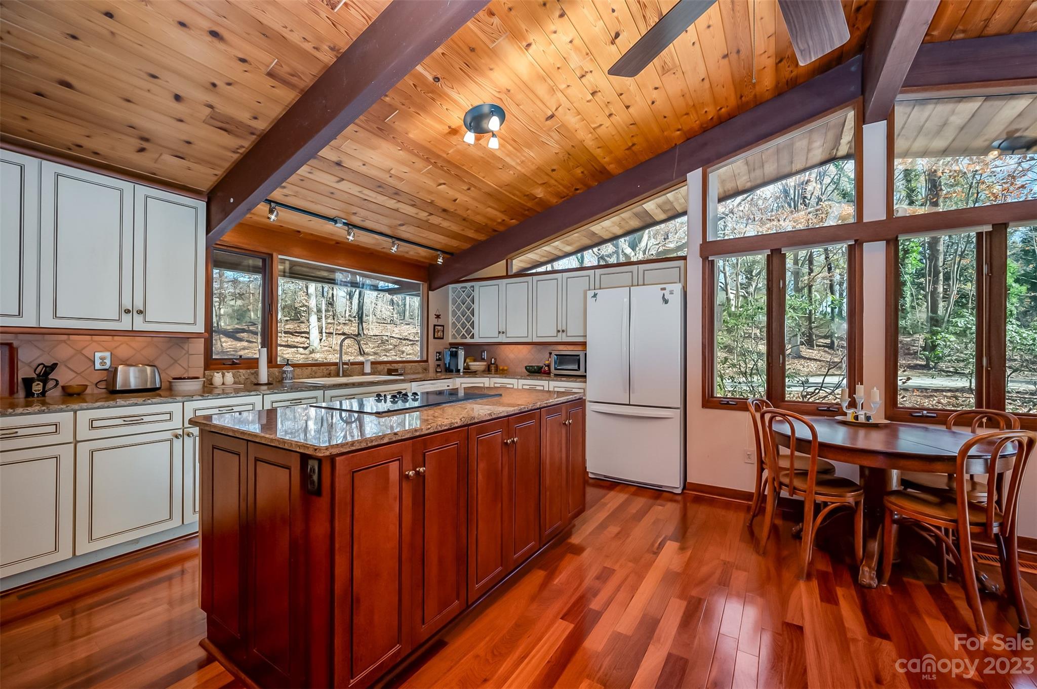 548 Howard Gap Road Tryon, NC 28782 - Photo 20 of 48 a kitchen with stainless steel appliances granite countertop a stove a refrigerator a table and chairs with wooden floor
