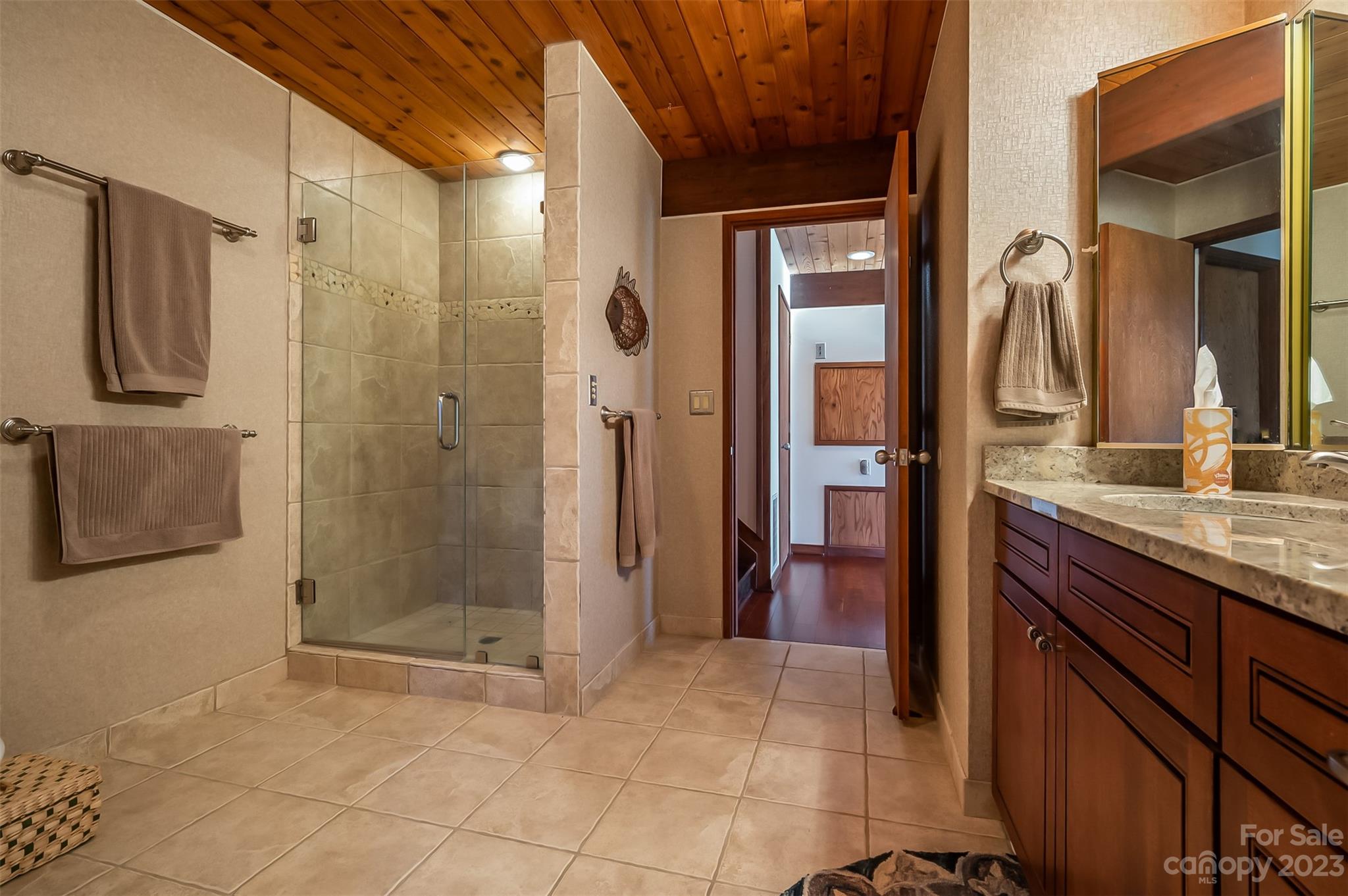 548 Howard Gap Road Tryon, NC 28782 - Photo 38 of 48 a bathroom with a granite countertop shower a sink and a mirror