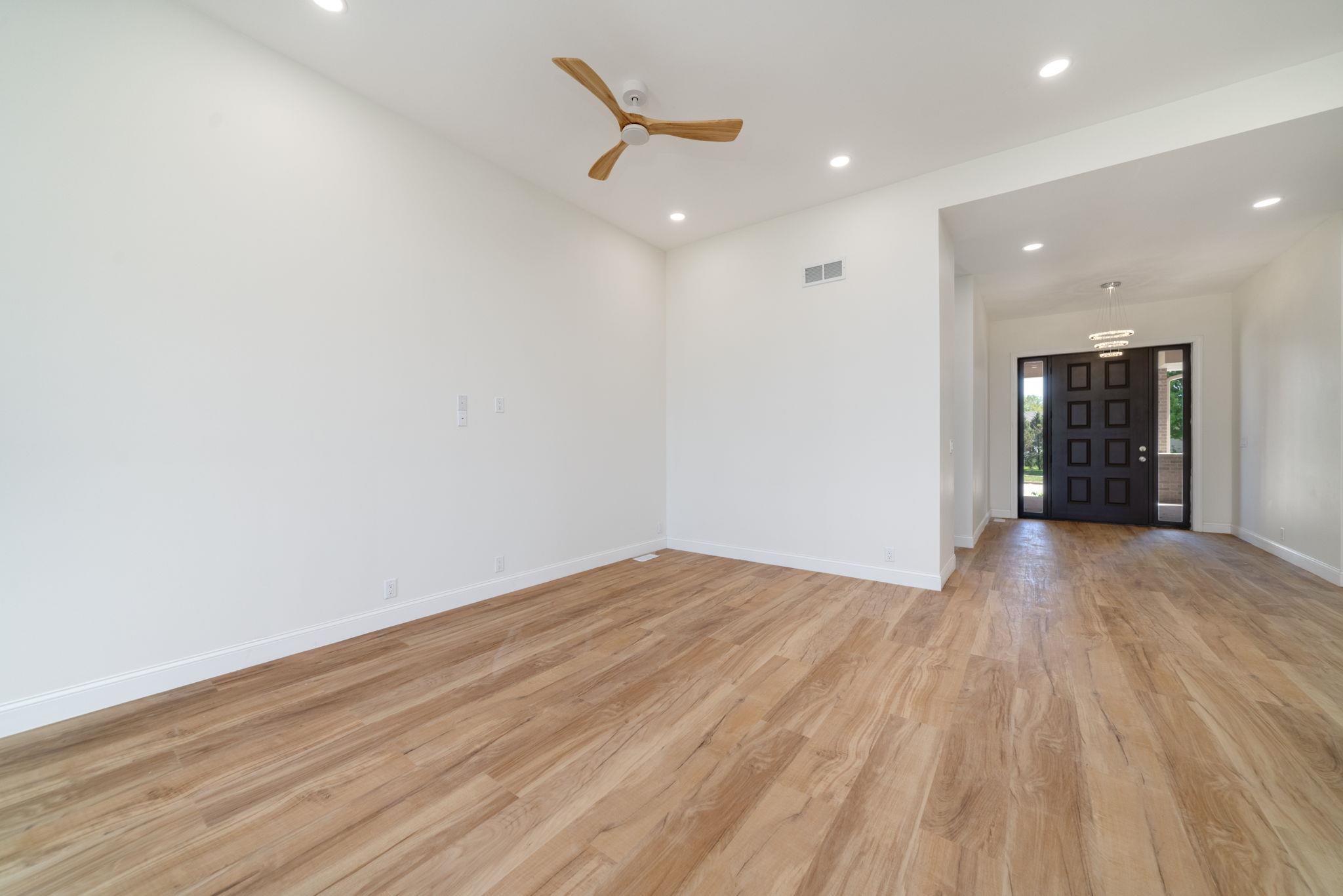 5145 Sycamore Ridge Road Belvidere, IL 61008 - Photo 9 of 57 a view of an empty room with wooden floor and a ceiling fan