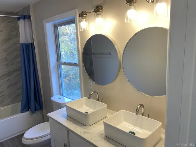 a bathroom with a toilet sink and mirror