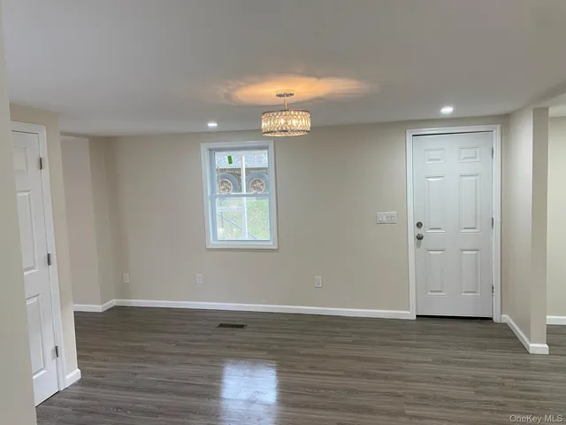 a view of a room with wooden floor and window