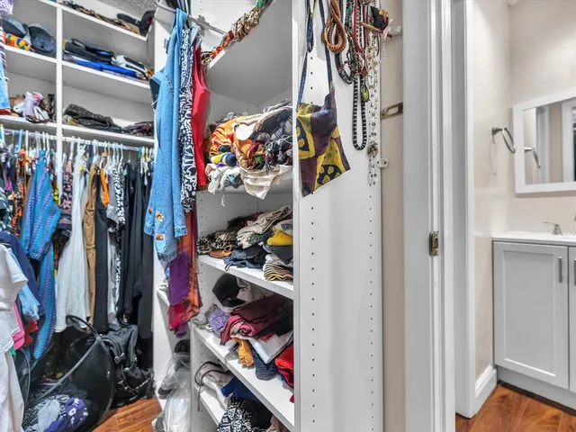 a view of walk in closet with clothes and shoes